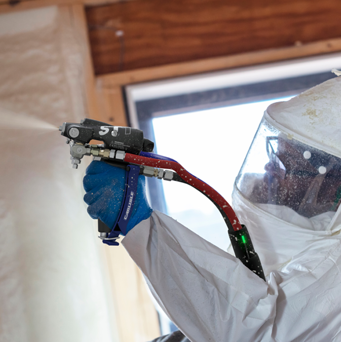 Technician using spray gun for precision spray foam application.